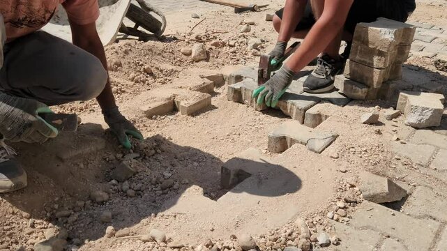 Stone pavers repair interlocking paving stones on a sidewalk
