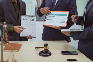 Three lawyers in a meeting at the table in an office, discussing business, civil and commercial...
