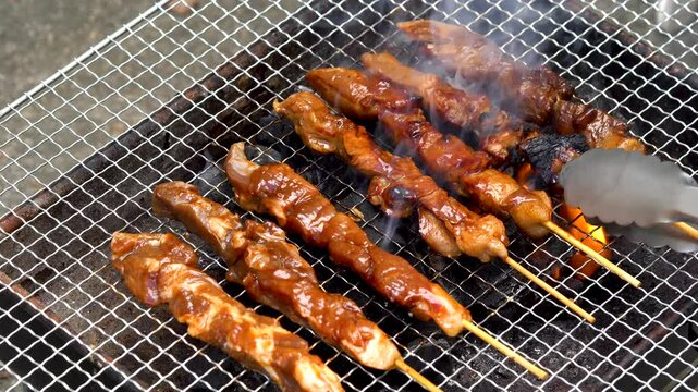 flipping pork barbecue; a famous Filipino street food 
