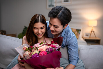 Asian young man surprise and give rose flower to beautiful girlfriend. 