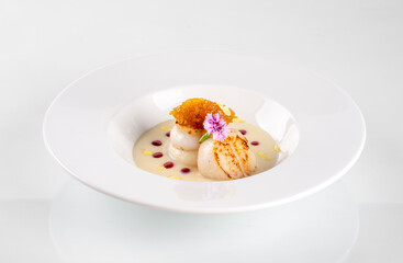Elegant gourmet dessert with delicate plating on a white plate, featuring ice cream, sauce, and a...