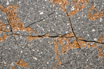 Obraz premium Cracked granite with a rough natural surface showing earthy grey and brown tones.