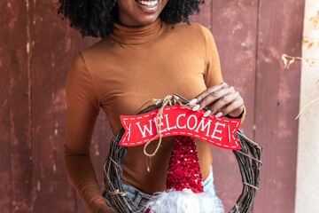 Radiant woman showcasing a red festive wreath