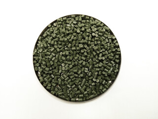 green masterbatch raw material, green polymer granules cold cut type, inside laboratory pantry dish, isolated on white background, for plastic industry profile product catalog design