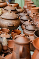 Rows of traditional ethnic pottery in the assortment at the fair outdoor, close-up, vertical format, selective focus.