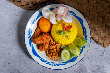 Indonesian traditional and signature dish, yellow rice served on an old plate. Top view