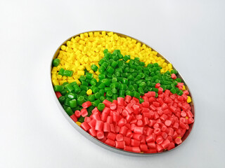 colorful masterbatch granule, colorful pigment, green granules in a cup, cold cutting type granule texture, isolated on white background, for industrial plastic company profile product catalog design
