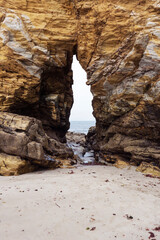 Arco excavado en la roca durante miles de años por la fuerza del agua en una playa de Tapia de Casariego, Asturias, España