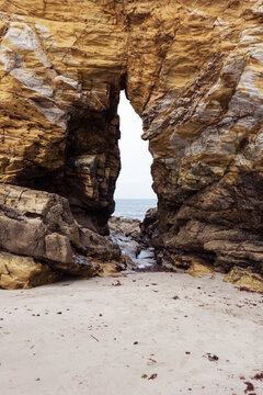 Arco excavado en la roca durante miles de a&ntilde;os por la fuerza del agua en una playa de Tapia de Casariego, Asturias, Espa&ntilde;a