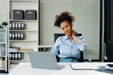 Obraz premium Overworked young businesswoman office worker suffering from neck pain after had a long day. office syndrome concept