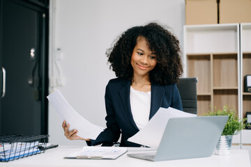 oung businesswoman working with working notepad, tablet and laptop documents talking on the smartphone, tablet