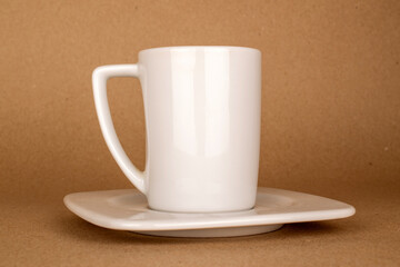 One ceramic cup and saucer on kraft paper, macro.