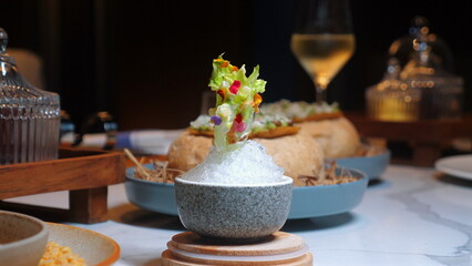 Chef presents gourmet dining experience with beautifully plated dish, featuring fresh salad and glass of white wine in elegant restaurant setting. Fine Dining and Culinary Artistry