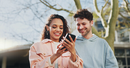 Phone, smile and couple outdoor on date, travel or reading blog in city together. Mobile, happy man and interracial woman at park on app for online forum, watch video and scroll social media profile