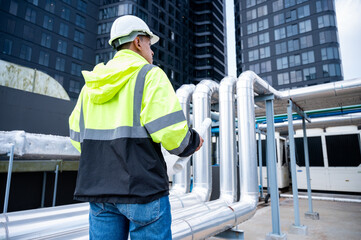 The technician carefully inspecting a section of pipeline during a construction project,...