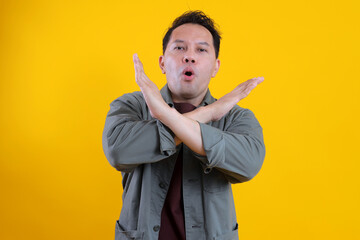 Young Serious Guy Crossed Hands Show No Stop Symbol Isolated On Bright Yellow Background