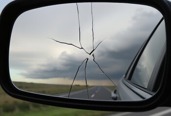 Cracked rearview mirror with a distant storm – A rearview mirr