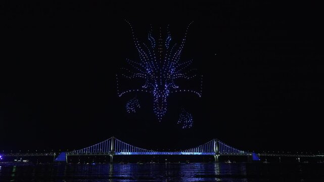 Glowing Flying Drones Hive Froming 3d Dragon Head in Night Sky.
Gwangalli Beach Drone Light Show Above Gwangan Bridge in Busan, South Korea.