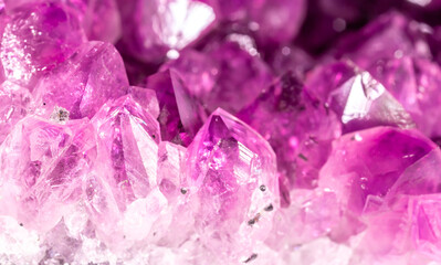 Amethyst pink crystals. Gems. Mineral crystals in the natural environment. Texture of precious and semiprecious stones. Seamless background with copy space colored shiny surface of precious stones.