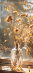 Obraz premium Sunlit Vintage Glass Vase with Dried Flowers by Window