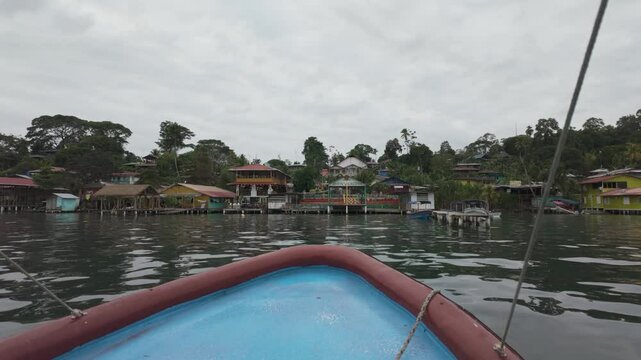 Boat approaching colorful waterfront houses on Bastimentos Island, Bocas del Toro, Panama
