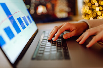 A person typing on a laptop in a cozy setting decorated with warm holiday lights during the festive season. . Business, Freelance, Shopping, education. Online. Cyber security concept