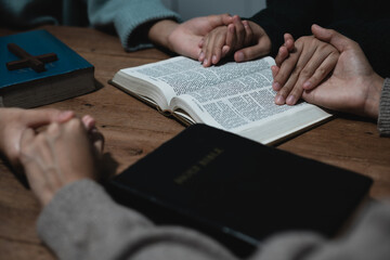 Closeup of simple wooden Christian cross on Bible. Concept of hope, faith, christianity, religion.