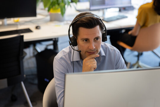 Businessman with headset on a video call in an office