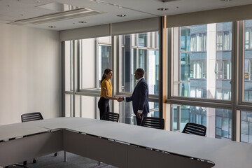 Business persons handshake in a modern office with views of buildings