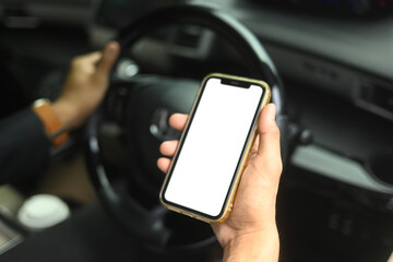 Close up shot of holding a smartphone with a blank screen while sitting in the driver seat of a car