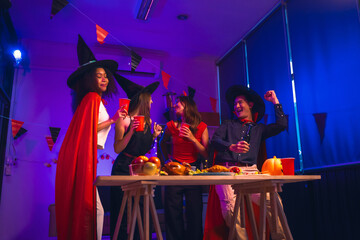 Asian friends, middle-aged man and young woman, enjoy Halloween office party with vampire costumes,...
