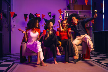 Asian friends, middle-aged man and young woman, enjoy Halloween office party with vampire costumes,...