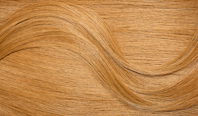 Red hair close-up as a background. Women's long orange hair. Beautifully styled wavy shiny curls. Hair coloring bright shades. Hairdressing procedures, extension.