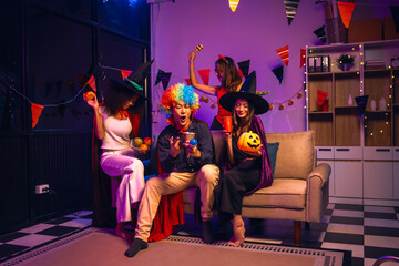 Asian friends, middle-aged man and young woman, enjoy Halloween office party with vampire costumes,...