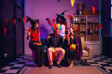 Asian friends, middle-aged man and young woman, enjoy Halloween office party with vampire costumes,...