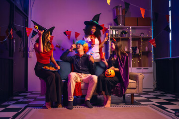 Asian friends, middle-aged man and young woman, enjoy Halloween office party with vampire costumes,...