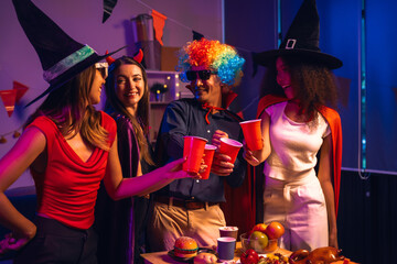 Asian friends, middle-aged man and young woman, enjoy Halloween office party with vampire costumes,...