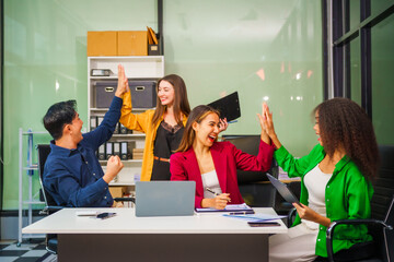 Asian colleagues, middle-aged man and young woman, happily collaborate in office workplace. They gather around laptop, discussing project management, startup plans, teamwork paper stacks on desk.
