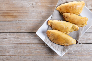 Pumpkin empanadillas for Halloween or Thanksgiving's Day on wooden table. Top view. Copy space