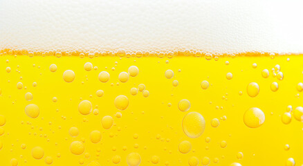 Beer glass showing frothy foam and bubbles, Beer background with refreshing texture and golden color.