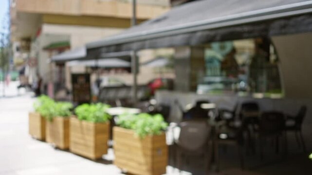 Blurred caf&eacute; exterior with outdoor seating on a sunny day in a european city center