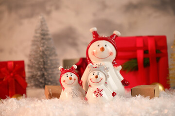 Funny snowmen figures and Christmas decor on artificial snow
