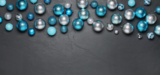 Different Christmas balls on grey textured background, flat lay. Space for text