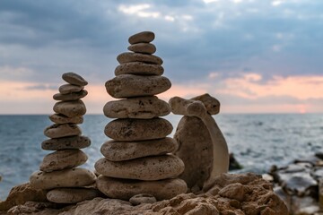Stone Cairns Beach Ocean - Three stone cairns stacked on a sandy beach by the ocean.