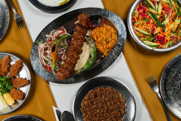 Top view, traditional Turkish cuisine and table setting, adana kebab, food service, appetizers and dishes.
