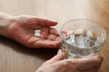 薬を飲む高齢女性の手元