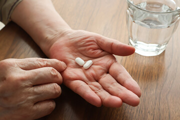 薬を飲む高齢女性の手元
