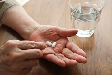 薬を飲む高齢女性の手元