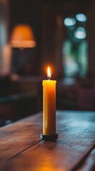 Lit candle on wooden table in cozy