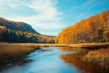 Fototapeta premium Tranquil river winding through autumn valley surrounded by golden trees and blue sky, Ai Generation